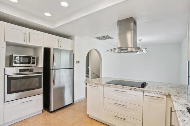 a kitchen with appliances a sink and cabinets