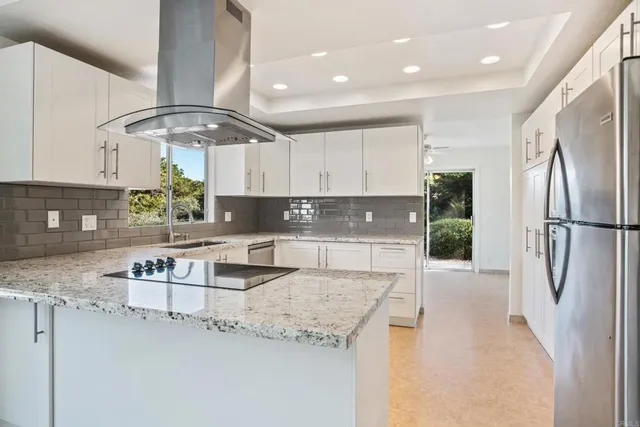a kitchen with stainless steel appliances granite countertop a sink refrigerator and cabinets