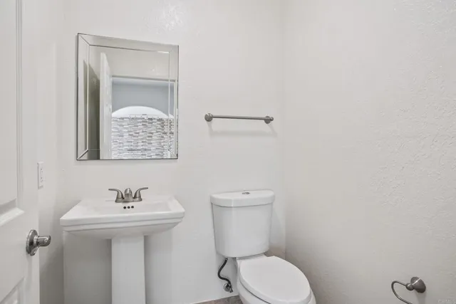 a bathroom with a toilet sink and mirror
