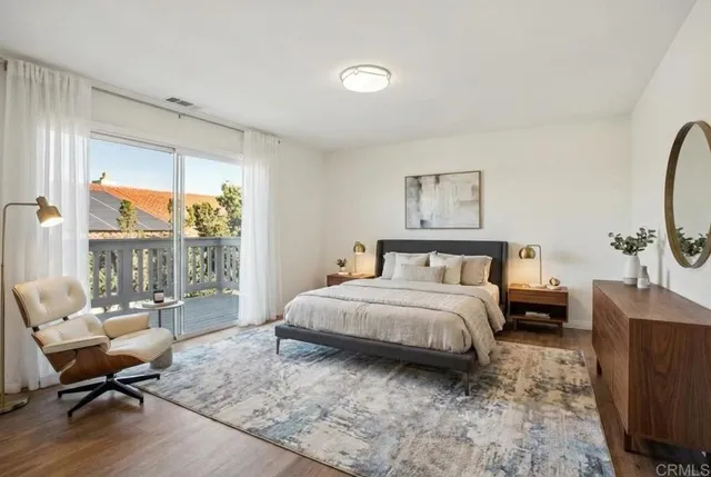 a spacious bedroom with a bed a couch and large window