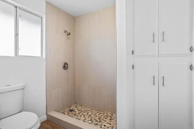 a bathroom with a toilet and a shower