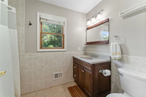 a bathroom with a granite countertop toilet a sink and a mirror