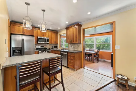a kitchen with stainless steel appliances granite countertop a refrigerator a sink a stove and island