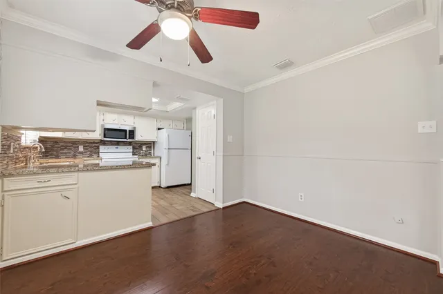a kitchen with granite countertop stainless steel appliances and wooden floor