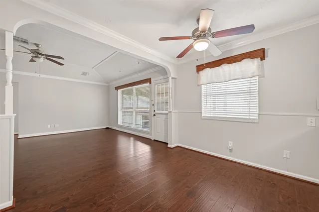 a view of an empty room with a window and wooden floor