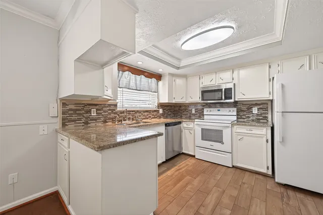 a kitchen with white cabinets and white appliances