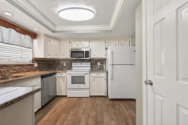 a kitchen with white cabinets and white appliances