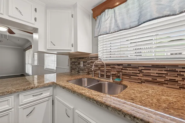a kitchen with granite countertop a sink and a stove