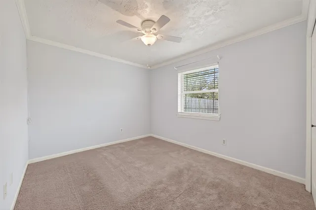 an empty room with windows and ceiling fan