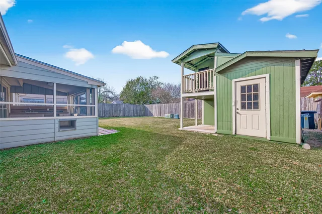 a view of a backyard with a garden and deck