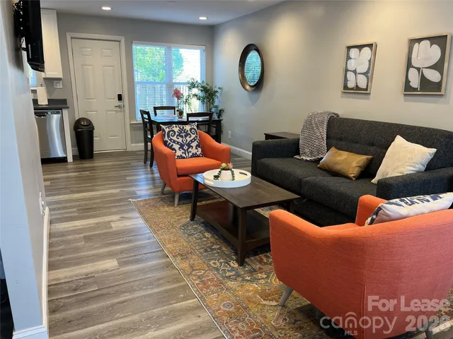 a living room with furniture wooden floor and a large window