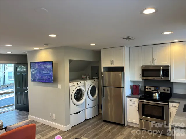 a kitchen with a refrigerator a stove top oven a sink and cabinets