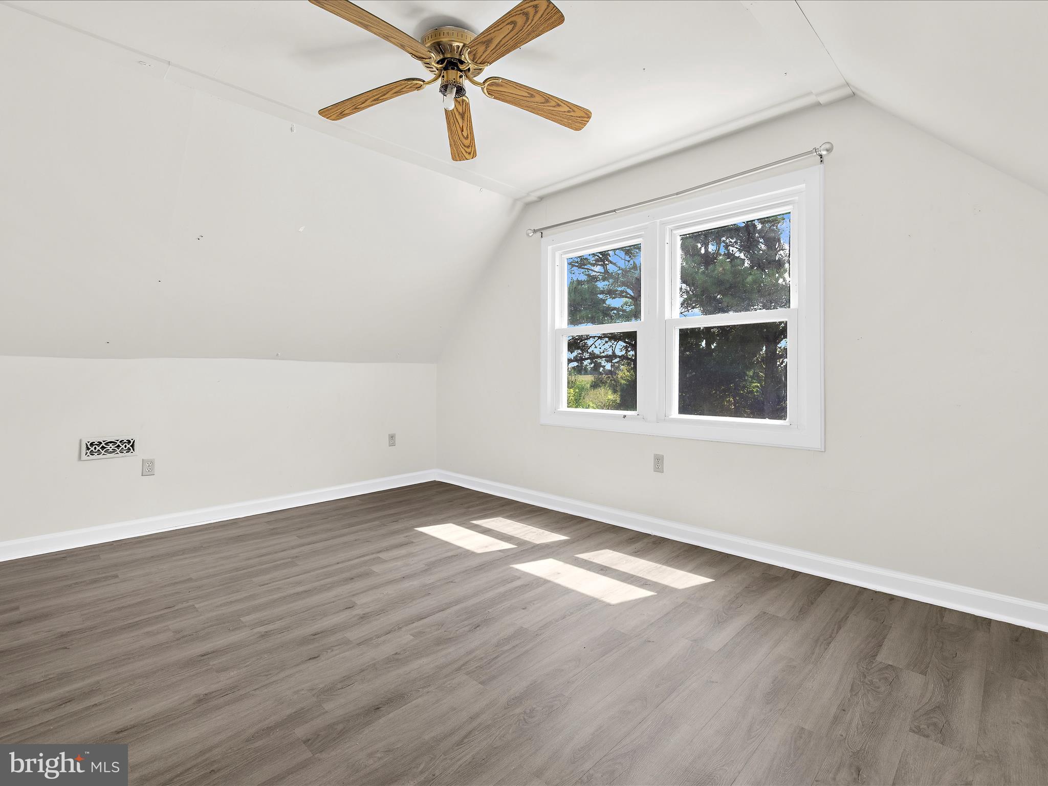 812 Roe Road Barclay, MD 21607 - Photo 18 of 46 an empty room with wooden floor chandelier fan and windows