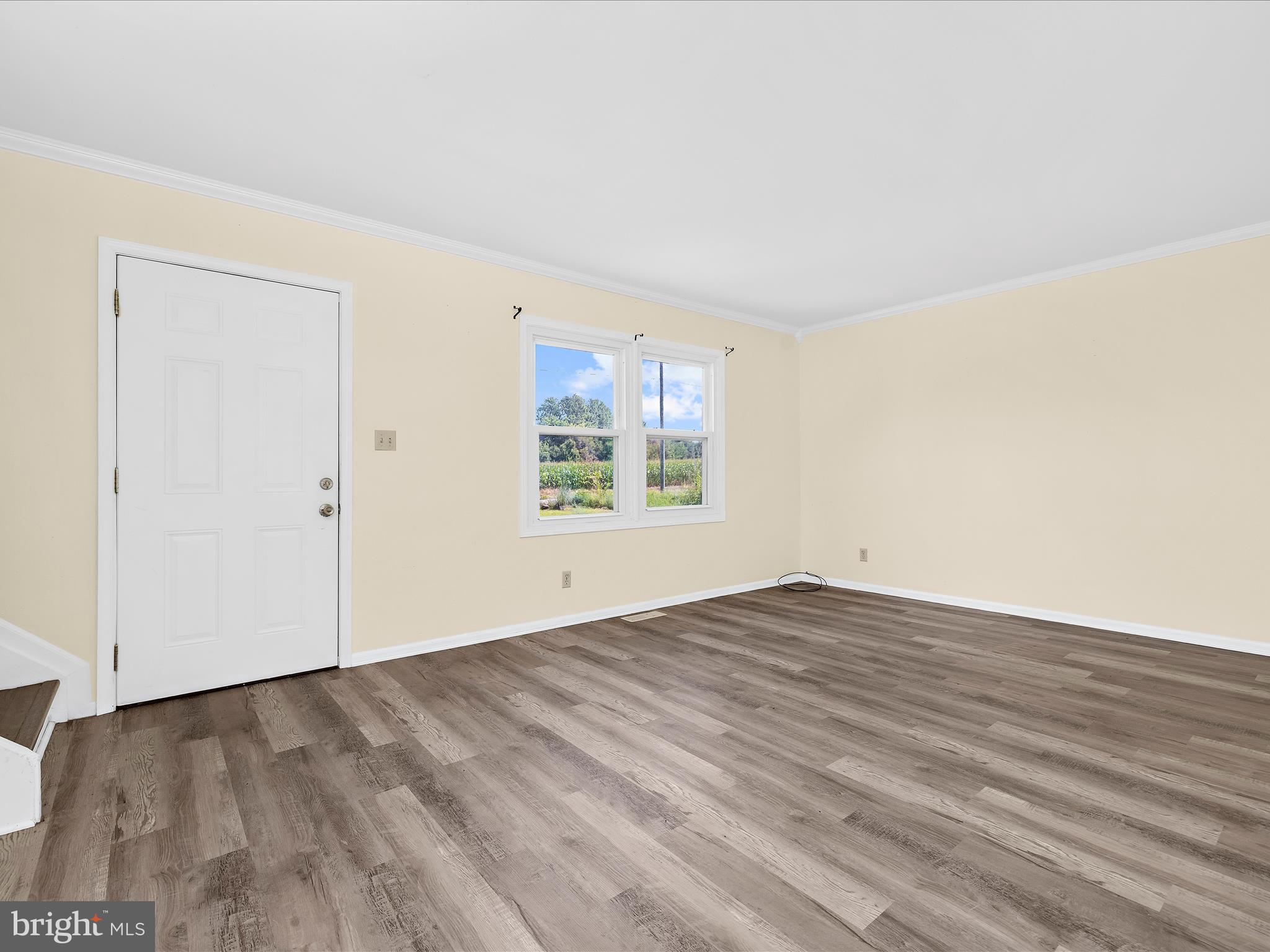 812 Roe Road Barclay, MD 21607 - Photo 5 of 46 an empty room with wooden floor cabinet and windows