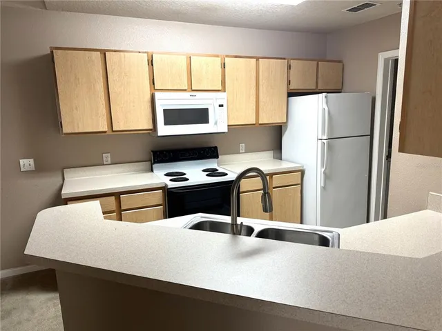 a kitchen with stainless steel appliances a refrigerator sink and cabinets