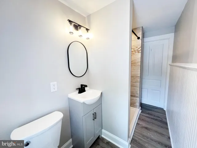a bathroom with a toilet sink and a mirror