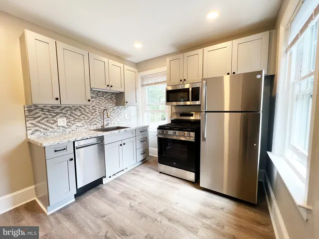 a kitchen with a refrigerator stove and white cabinets