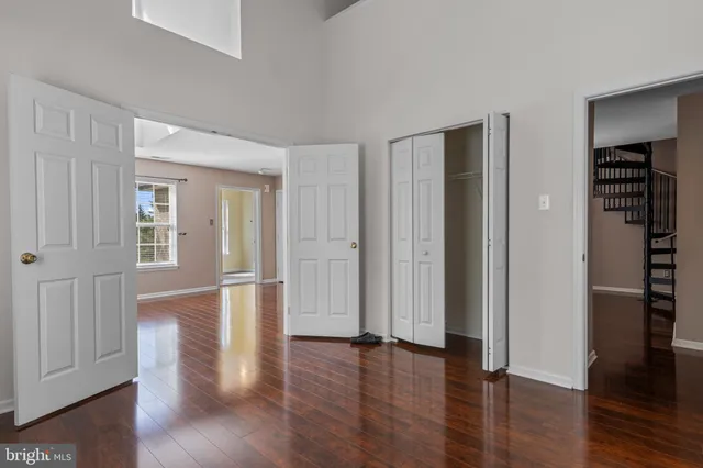 an empty room with wooden floor & closet area