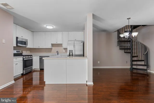 a kitchen with granite countertop a refrigerator and a stove top oven