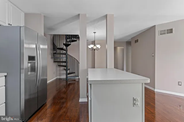 a kitchen with kitchen island white cabinets and stainless steel appliances