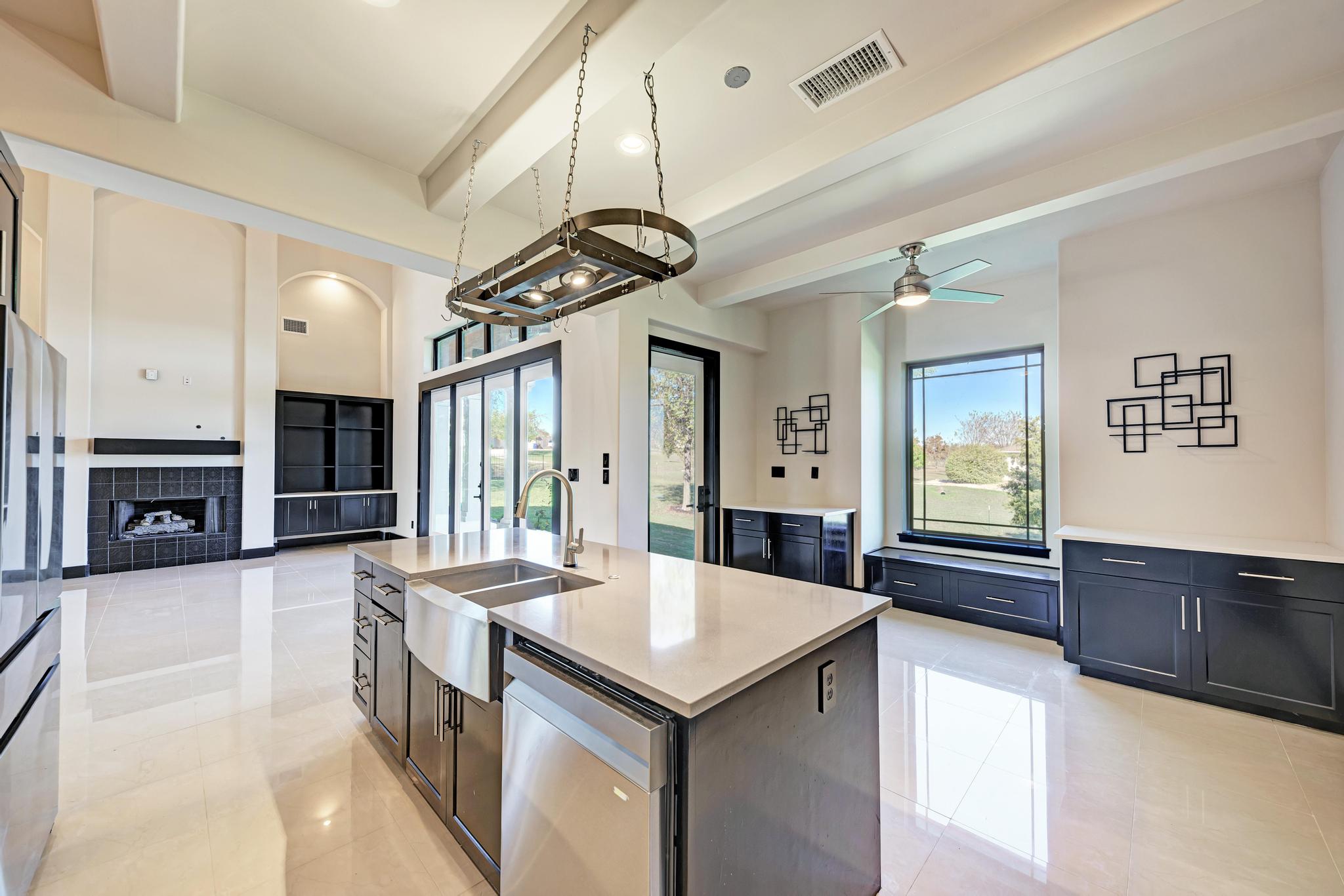 104 Spring Valley Street Hutto, TX 78634 - Photo 39 of 40 Kitchen featuring a kitchen island with sink, light stone countertops, open floor plan, beam ceiling, and stainless steel appliances