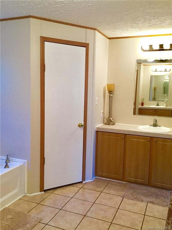 119 Forney Road, Unit 1 Olin, NC 28660 - Photo 11 of 17 a bathroom with a sink a mirror and a bathtub