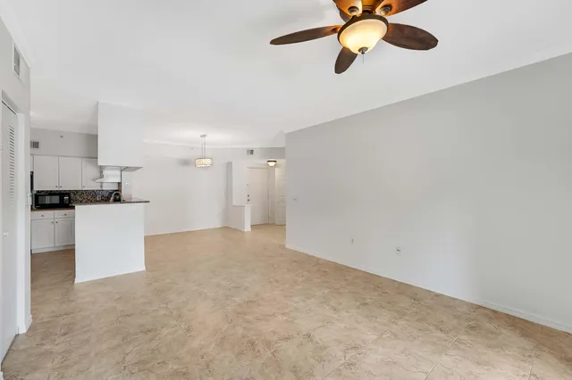a kitchen with granite countertop a sink white cabinets and stainless steel appliances