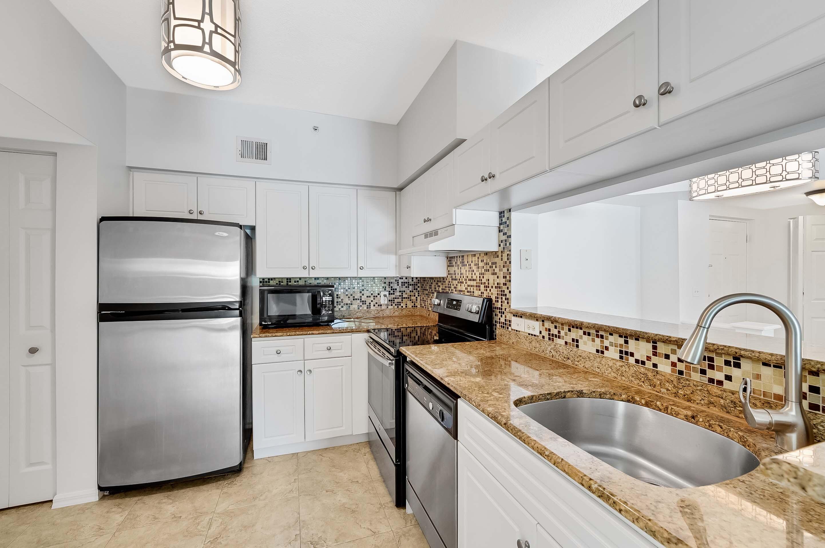 3115 Tuscany Way Boynton Beach, FL 33435 - Photo 22 of 49 a kitchen with a refrigerator sink and white stove