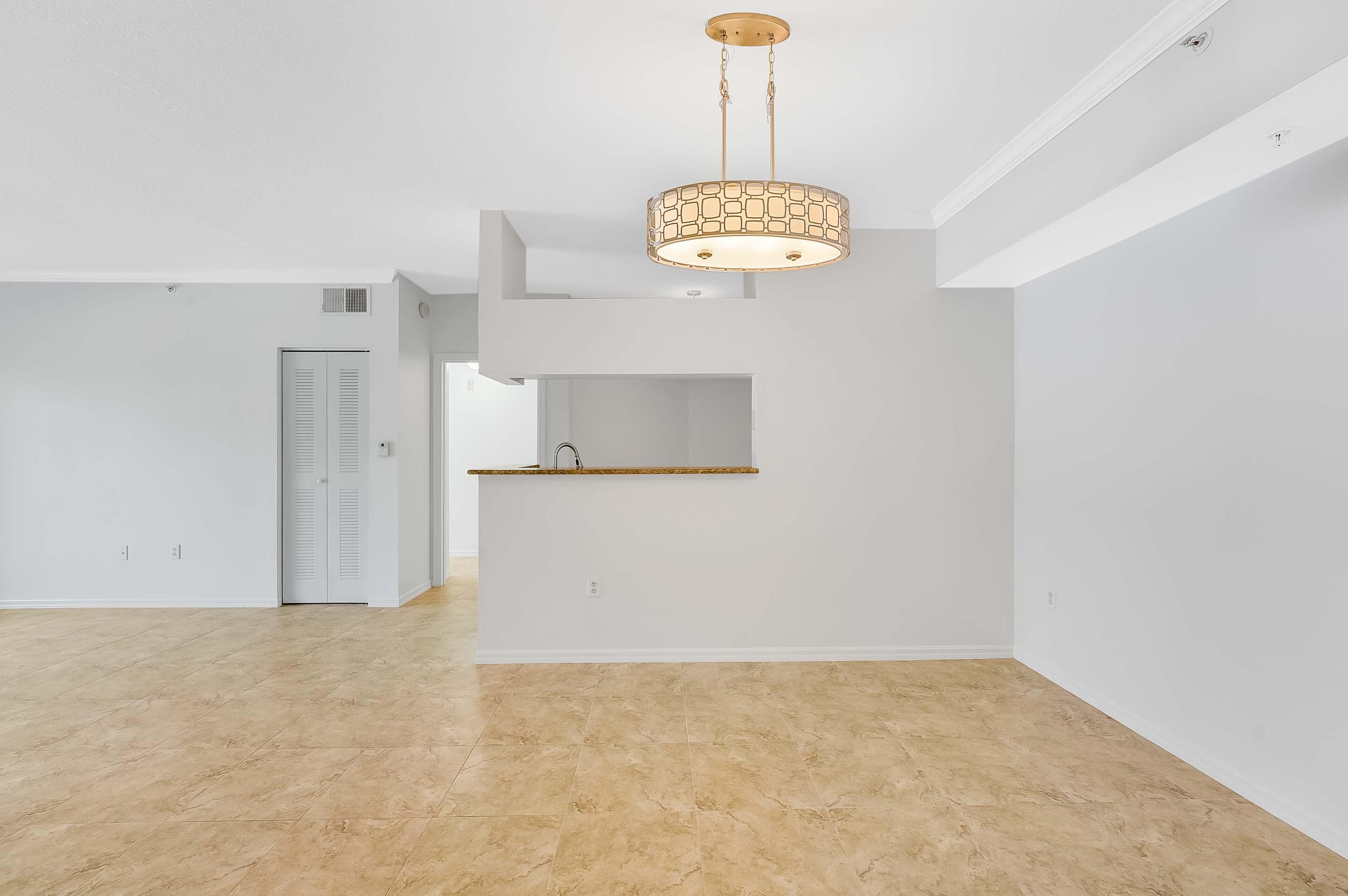 3115 Tuscany Way Boynton Beach, FL 33435 - Photo 29 of 49 a view of a hallway with a kitchen space and a chandelier