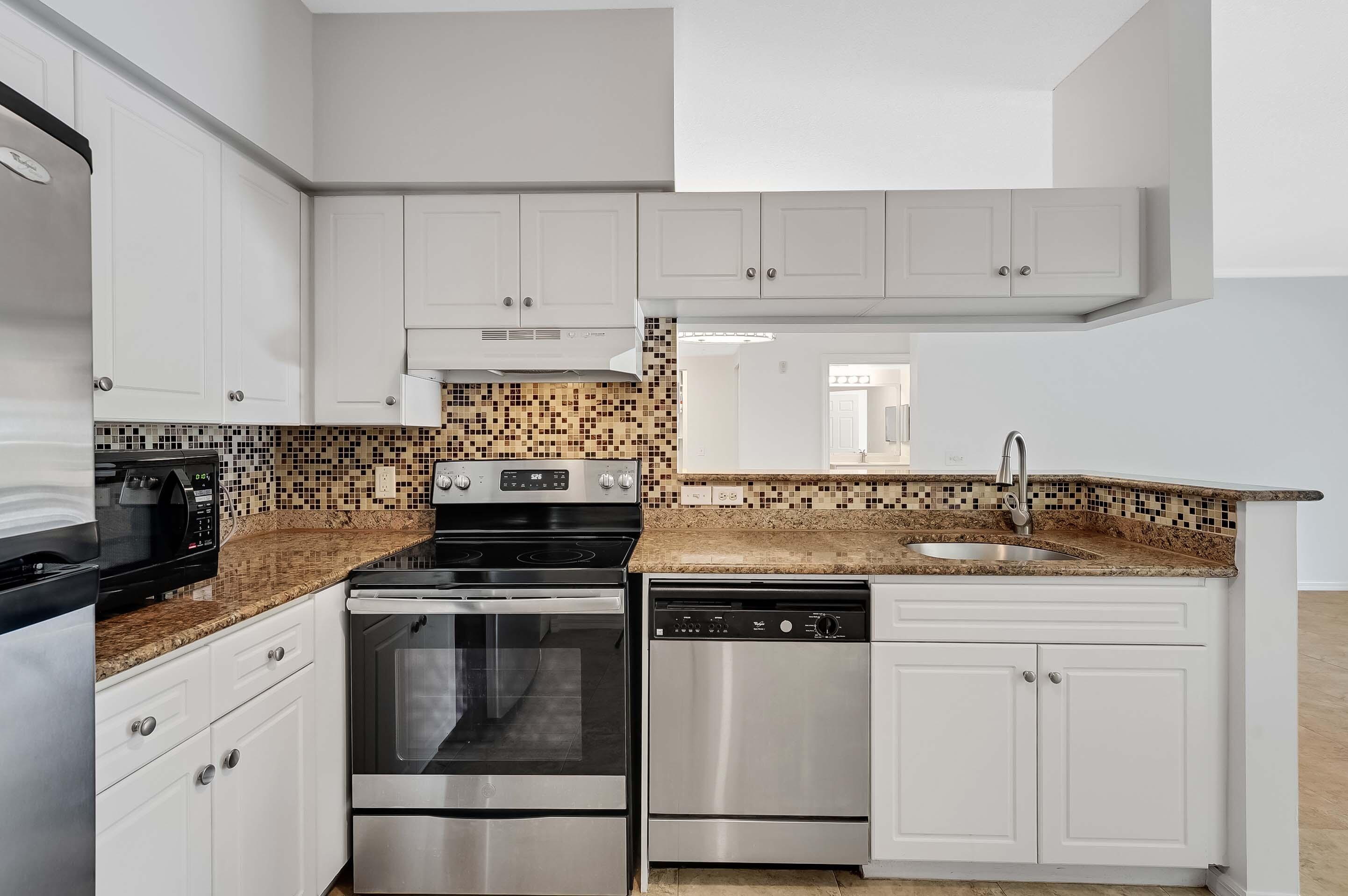 3115 Tuscany Way Boynton Beach, FL 33435 - Photo 31 of 49 a kitchen with white cabinets and appliances