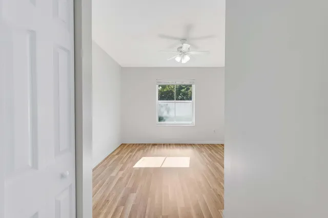 a view of a room with wooden floor and a ceiling fan