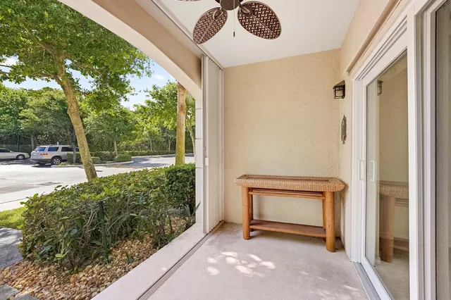 a view of a white house with a large trees