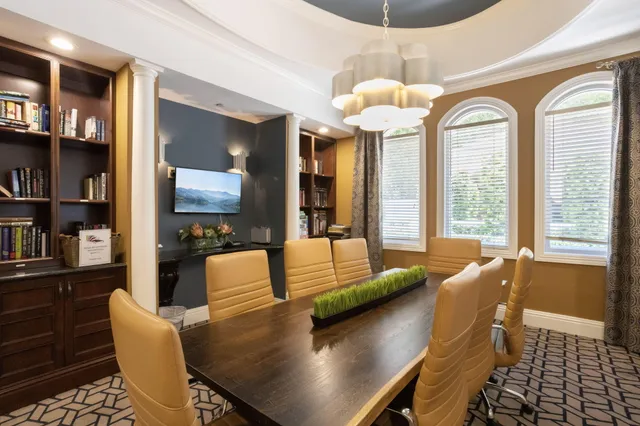 a view of a dining room with furniture a chandelier and wooden floor