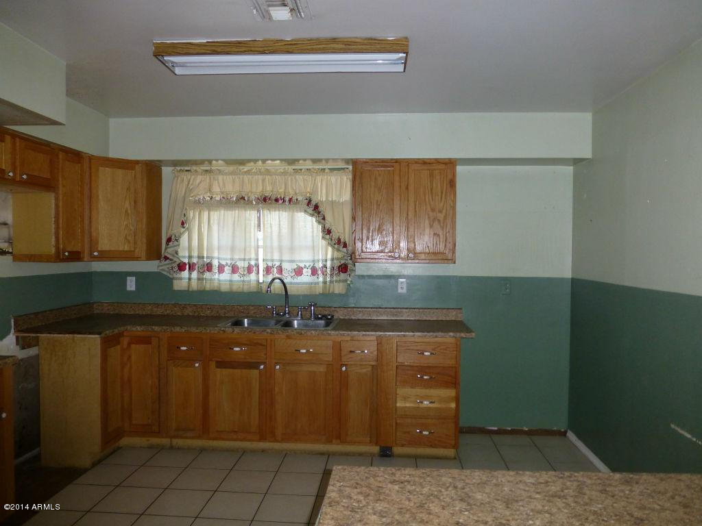 3848 West Ocotillo Road Phoenix, AZ 85019 - Photo 3 of 22 a kitchen with sink cabinets and window