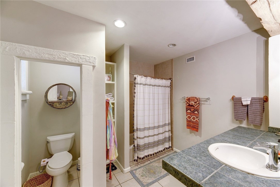 1712 Lakeshore Drive, Unit A Austin, TX 78746 - Photo 14 of 15 a bathroom with a granite countertop toilet and a sink