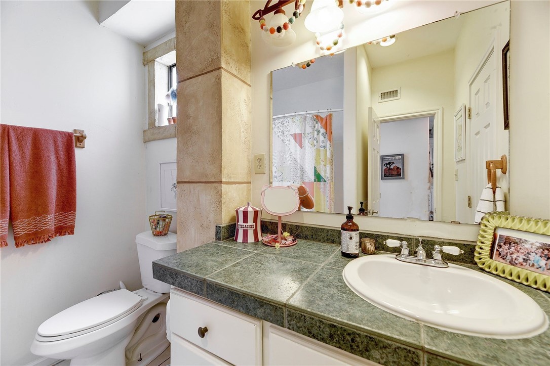 1712 Lakeshore Drive, Unit A Austin, TX 78746 - Photo 8 of 15 a bathroom with a granite countertop double vanity sink and a mirror