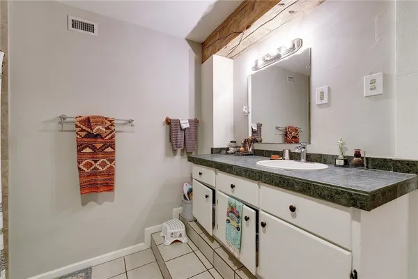 a bathroom with a granite countertop sink and a mirror