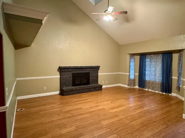 a view of empty room with a fireplace and fan