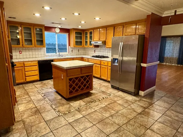a kitchen with stainless steel appliances granite countertop a stove a refrigerator and a oven
