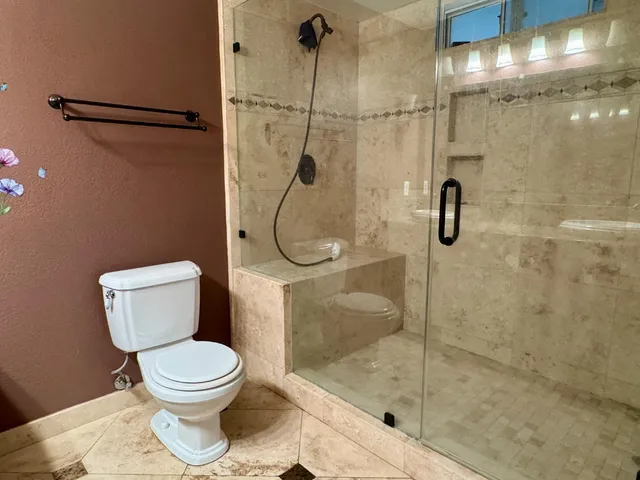 a bathroom with a toilet and a shower