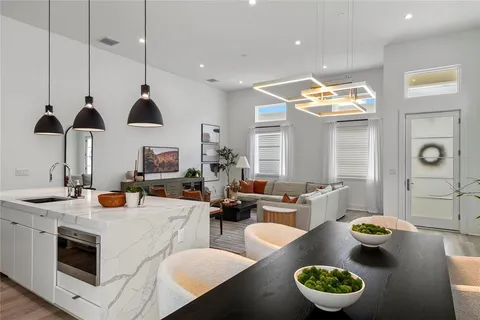 a kitchen with stainless steel appliances a stove a kitchen island a dining table and chairs