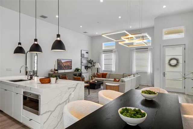 a kitchen with stainless steel appliances a stove a kitchen island a dining table and chairs