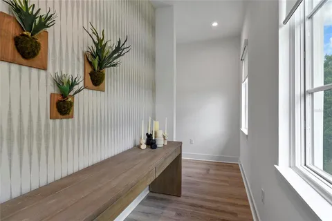a view of a hallway with wooden floor and a potted plant