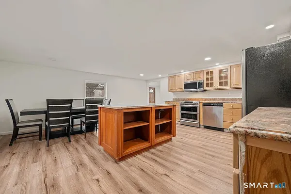 a open kitchen with stainless steel appliances granite countertop a stove and a refrigerator