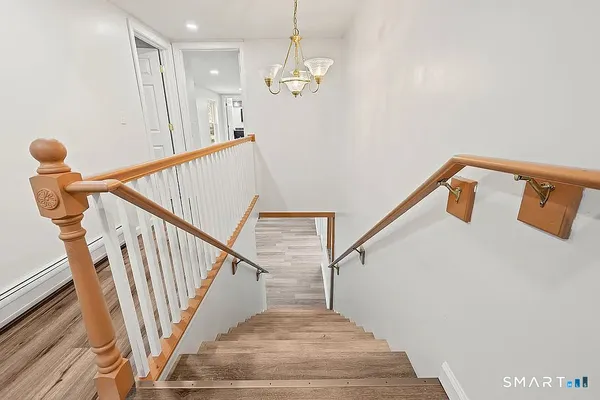 a view of entryway and hall with wooden floor