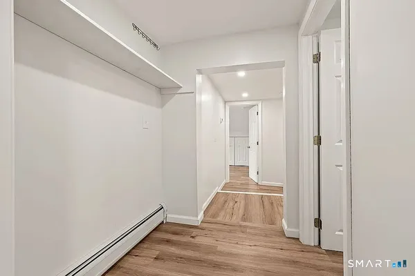 a view of a room with wooden floor and white walls