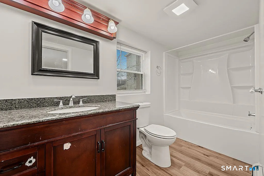 78 Union Street Bristol, CT 06010 - Photo 22 of 27 a bathroom with a granite countertop toilet sink and mirror