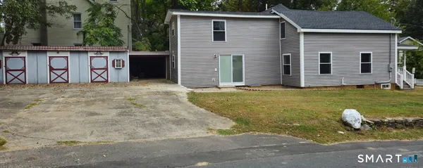 a view of a house with backyard and sitting area