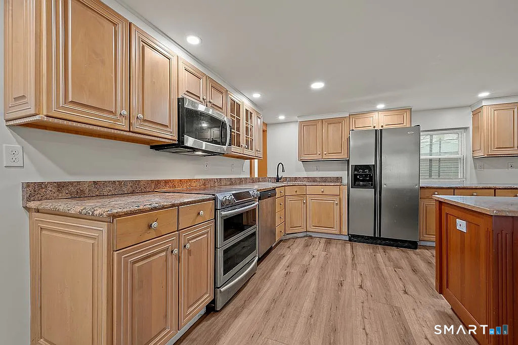 78 Union Street Bristol, CT 06010 - Photo 6 of 27 a kitchen with stainless steel appliances granite countertop a stove a sink and a refrigerator