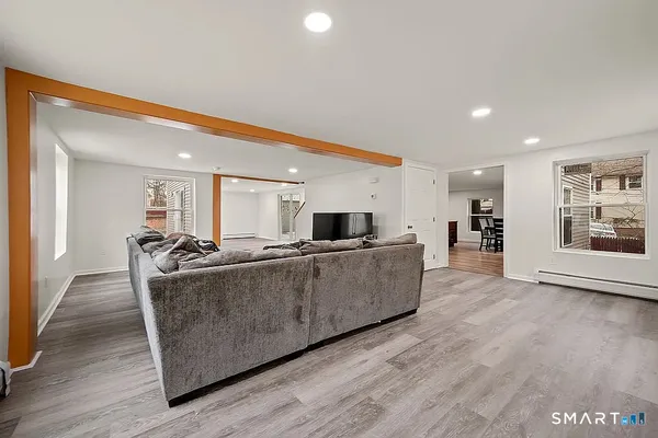 a living room with furniture a wooden floor and a large window